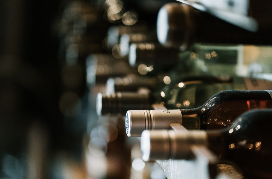 Wine bottles resting on their sides on a rack in a softly lit pub interior