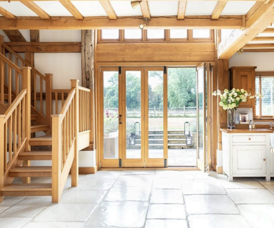 Entrance area with oak staircase on the left and glazed doors opening onto the terrace